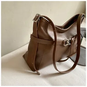 Détail du sac cabas en cuir marron foncé avec chaîne métallique et boucle de réglage