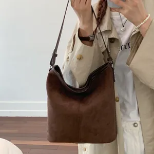 Detailansicht der dunkelbraunen Wildleder-Beuteltasche mit verstellbarem Riemen und Matt-Optik