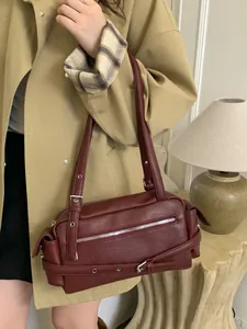 Vintage burgundy motorcycle shoulder bag with silver zippers and metal eyelet belt decor