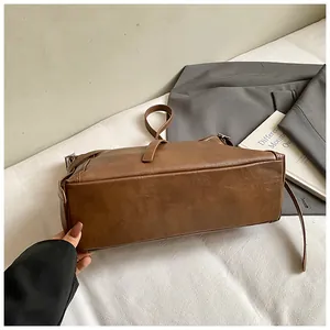 Détails du sac fourre-tout en cuir marron foncé et de sa bandoulière réglable texturée