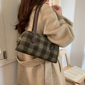 Détail du sac cabas à carreaux en laine verte et marron avec anses en cuir d'épaule