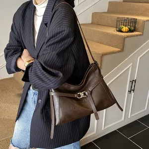 Détail du sac cabas vintage en cuir marron foncé avec boucle à anneau argenté élégante