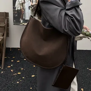 Détail du grand sac hobo marron avec coutures apparentes et petite pochette suspendue