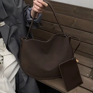 Détail du sac cabas mat marron foncé avec coutures tissées et pochette assortie