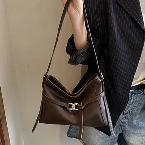 Gros plan du sac à bandoulière marron foncé vintage avec boucle en métal doré
