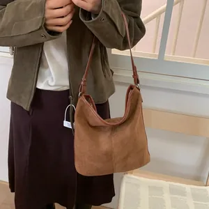 Detailansicht der braunen Hobo-Tasche aus Wildleder mit Naht und Lederriemen
