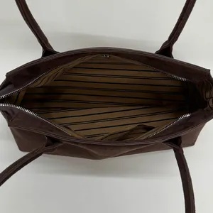 Vue détaillée du grand sac cabas en daim avec doublure rayée et fermeture éclair