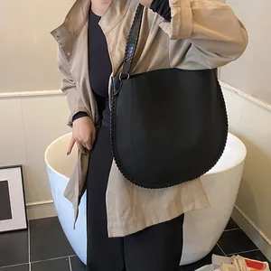 Détail d'un grand sac fourre-tout noir avec bord tressé dans un décor de studio d'art