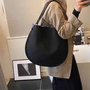Détail du sac cabas noir avec couture de bordure tressée et texture de tissu souple