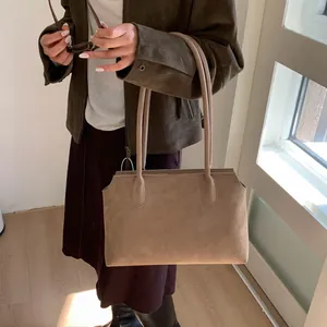 Détail du cabas minimaliste en daim kaki avec longue bandoulière pour un usage quotidien