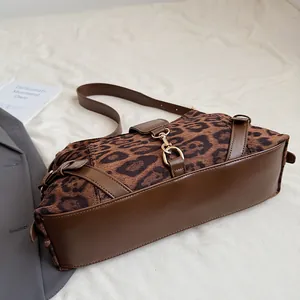 Detailansicht der Vintage-Umhängetasche mit Leopardenmuster und Goldschnalle auf Leinen