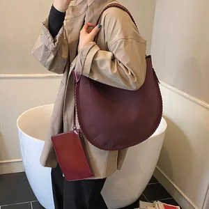 Détails du sac cabas bordeaux à bord tressé et pochette sur femme en trench-coat