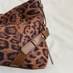 Details der Wildlederstruktur mit Leopardenmuster, Lederband und goldener Niete