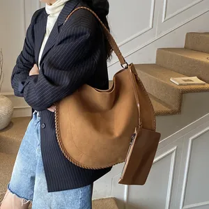Sac cabas en daim marron avec coutures tressées et mini pochette assortie sur modèle