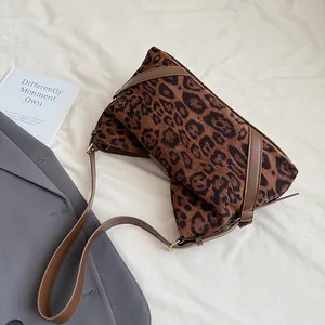 Detailaufnahme der Leoparden-Umhängetasche mit braunem Leder und goldener Schnalle