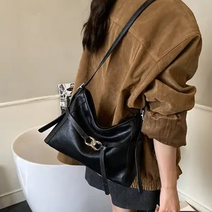 Détail d'un sac cabas vintage en cuir noir avec une boucle à double anneau argentée