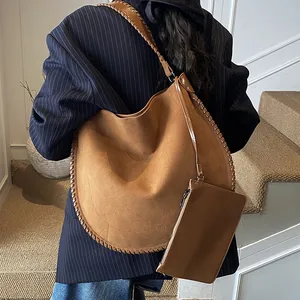 Sac hobo marron en daim avec détails tissés et pochette interne sur le mannequin