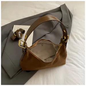 Détail du sac en daim marron montrant la doublure grise et la poche intérieure zippée