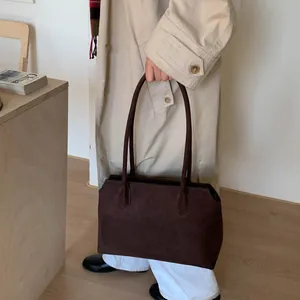 Détail du sac cabas minimaliste en daim marron foncé avec de fines bandoulières