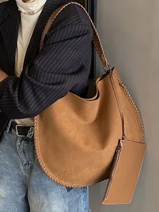 Grand sac cabas en daim marron avec bordure tressée porté par un mannequin