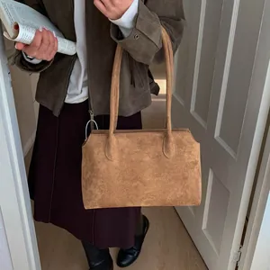 Gros plan détaillé du sac cabas en daim marron givré montrant la texture et les coutures