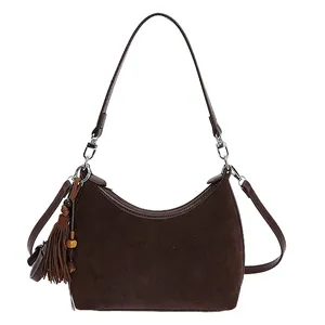 Minimalist dark brown suede hobo bag with moon-shaped design and tassel detail