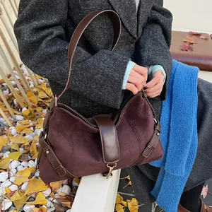 Detailansicht der großen braunen Wildledertasche mit goldenen Beschlägen und Trageriemen