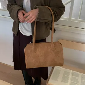 Détail du sac cabas en daim mat avec coutures goutte d'eau sur les bandoulières