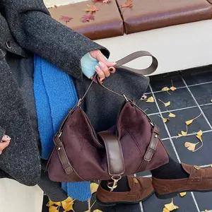 Nahaufnahme der braunen Wildledertasche mit Lederriemen und stilvoller Metallschnalle