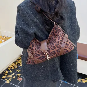 Detailaufnahme der Schultertasche mit Leopardenmuster, Lederriemen und Goldschnalle