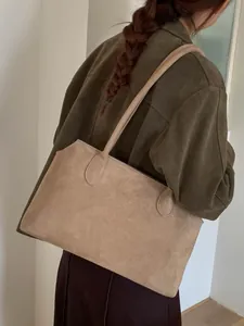 Sac fourre-tout minimaliste en daim marron clair au style vintage porté par un mannequin