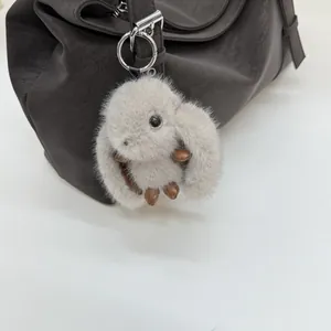 Détail d'un charmant lapin en peluche avec pattes en cuir sur un sac à main en cuir brun