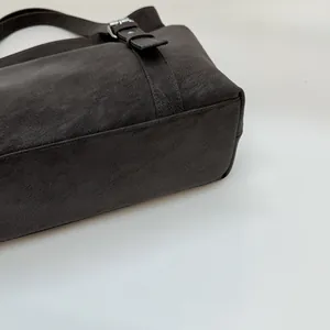 Gros plan du côté d'un sac marron rétro avec boucle argentée et texture cuir