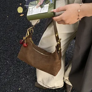 Détail du sac à bandoulière en cuir dépoli marron foncé avec cerise et boucle dorée