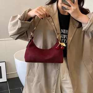 Gros plan du sac hobo en cuir givré bordeaux avec un pendentif cerise dorée
