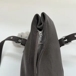 Gros plan détaillé sur la fermeture éclair argentée et le cuir suédé mat du sac fourre-tout