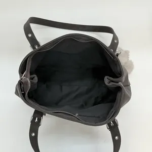 Vue de dessus de l'intérieur du sac à main spacieux avec poche zippée et détail de sangle