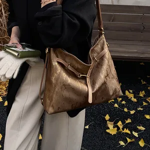 Detail of vintage bronze tote bag with marble texture and golden hardware in autumn setting