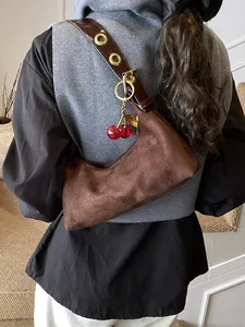 Sac sous le bras en daim marron avec pendentif cerise et sangle à œillets métalliques