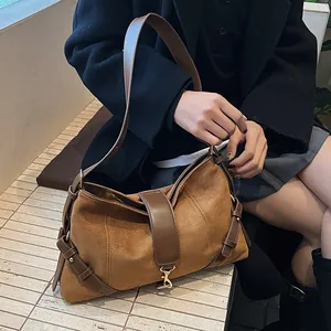Detail der braunen Wildleder-Schultertasche mit Retro-Messingschnalle und Lederriemen