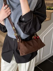 Sac à bandoulière vintage marron foncé mat avec pendentif cerise et œillets dorés