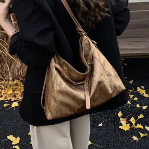 Detail of vintage bronze tote bag with leather straps on a scenic autumn background