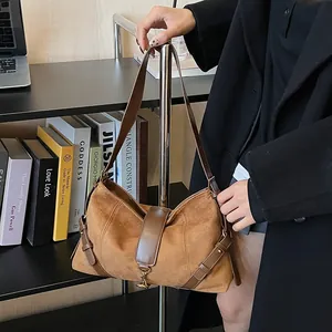 Detailansicht einer braunen Wildleder-Schultertasche mit Lederriemen und Metallverschluss