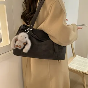 Détail du sac cabas marron foncé avec large bandoulière et breloque lapin en peluche