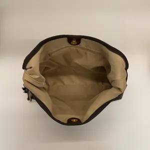 Vue macro de l'intérieur d'un sac cabas vintage avec fermoirs aimantés et poche zippée