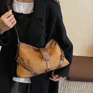 Detailaufnahme der braunen Wildleder-Umhängetasche im Retro-Stil mit goldenen Schnallen
