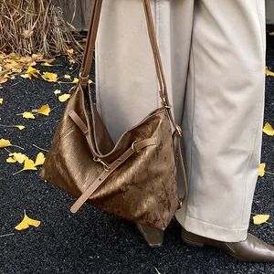 Close-up of bronze vintage tote bag with metallic texture and chic ring details