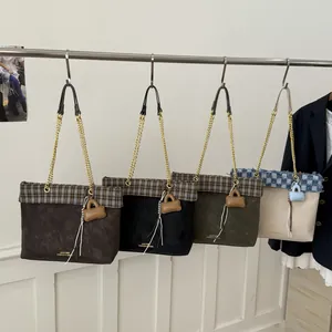 Mehrere schicke Plaid-Tote-Bags mit Goldketten, die in einer Modeboutique aufgehängt sind