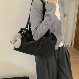 Détail du grand sac cabas noir en daim avec boucle argentée et pendentif ours doux