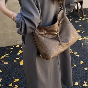 Detail of vintage brown tote bag with leather buckle and gold ring in autumn setting